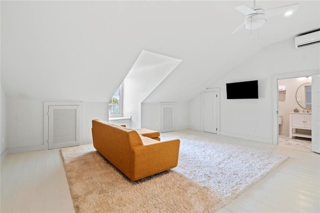 additional living space featuring lofted ceiling, a wall mounted AC, light hardwood / wood-style flooring, and ceiling fan