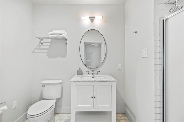 bathroom featuring toilet, a shower with shower door, and vanity