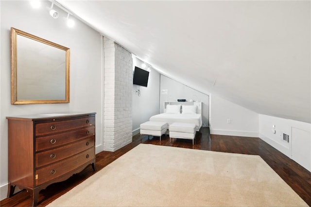 bedroom featuring lofted ceiling and dark hardwood / wood-style floors