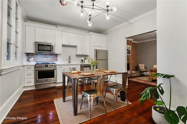 kitchen with white cabinets, stainless steel appliances, an inviting chandelier, and dark hardwood / wood-style flooring