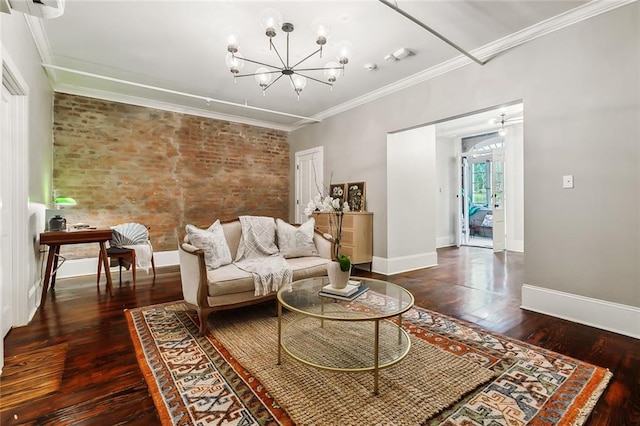 living room featuring brick wall, wood-type flooring, ornamental molding, and a chandelier