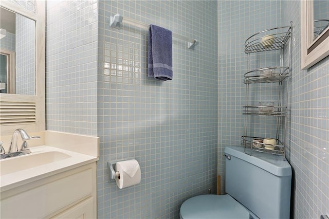 bathroom featuring tile walls, vanity, and toilet