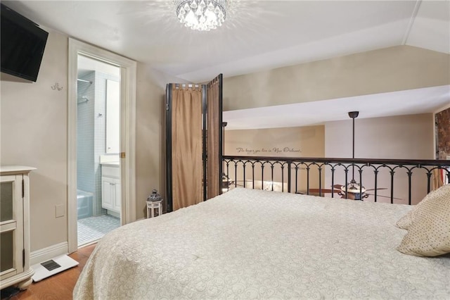 bedroom featuring a notable chandelier, wood-type flooring, connected bathroom, and vaulted ceiling