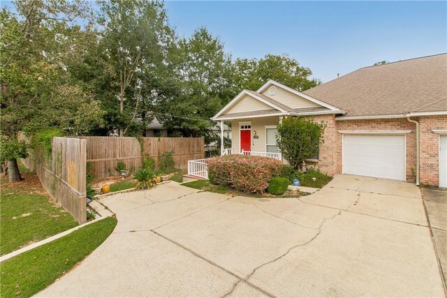 605 Florida St, Mandeville, LA 70448 - view of front facade with driveway, brick siding, and a garage