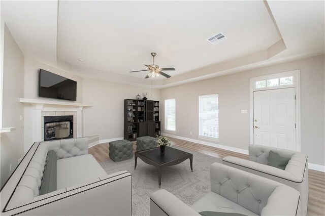 605 Florida St, Mandeville, LA 70448 - living room with a tray ceiling, wood finished floors, baseboards, and healthy amount of natural light