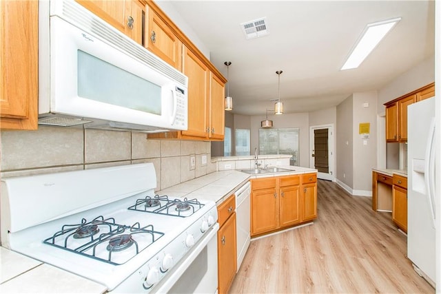 kitchen featuring light hardwood / wood-style floors, sink, backsplash, and white appliances