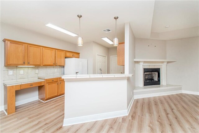 605 Florida St, Mandeville, LA 70448 - kitchen featuring white fridge with ice dispenser, tile countertops, and light wood finished floors