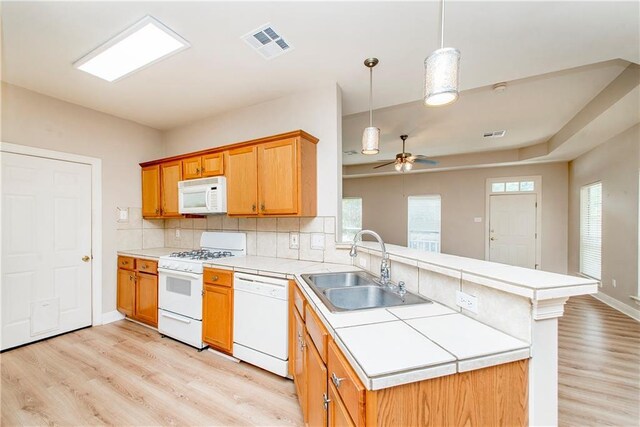 605 Florida St, Mandeville, LA 70448 - kitchen with white appliances, a sink, a peninsula, light wood-type flooring, and a ceiling fan