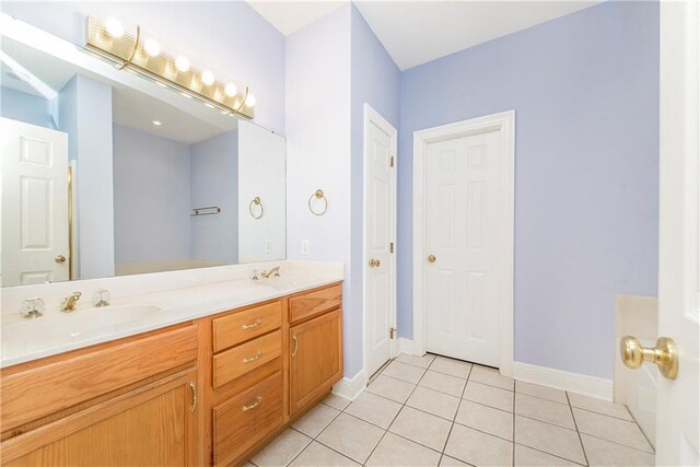 605 Florida St, Mandeville, LA 70448 - bathroom with double vanity, tile patterned flooring, and baseboards