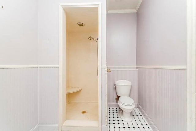 bathroom with ornamental molding, a shower, and toilet