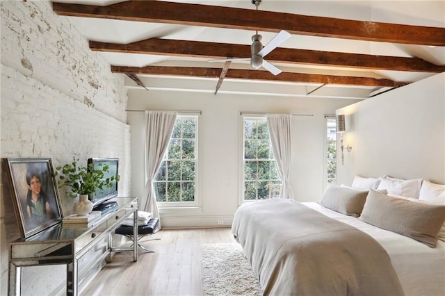 bedroom with light hardwood / wood-style flooring and vaulted ceiling with beams