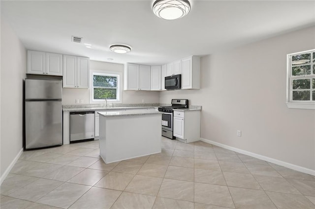 kitchen with white cabinets, stainless steel appliances, and light tile patterned flooring