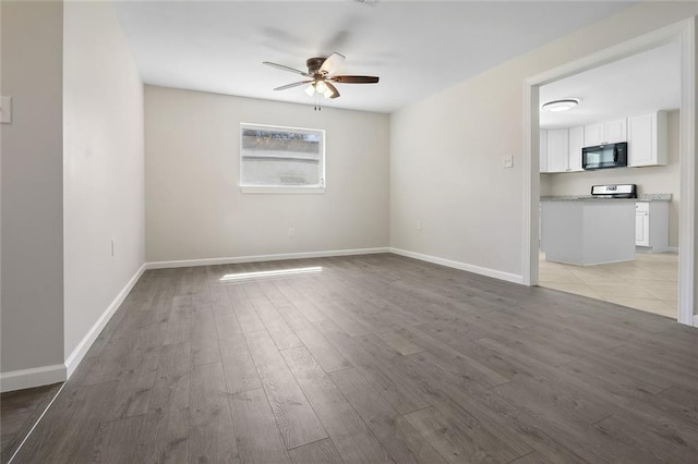 spare room featuring ceiling fan and light hardwood / wood-style flooring