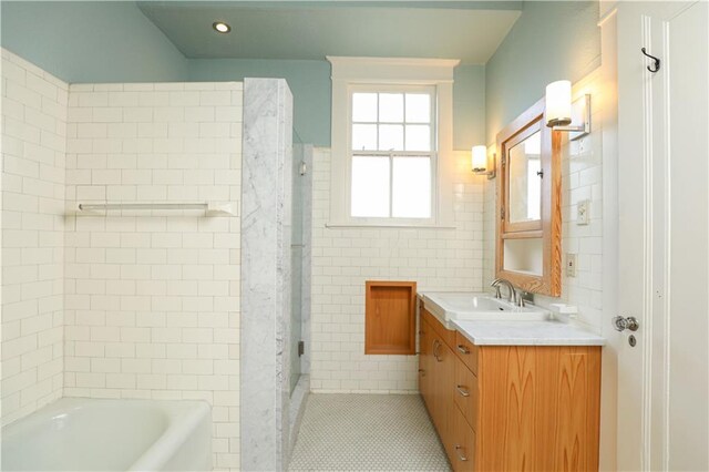 bathroom featuring vanity, tile walls, tile patterned flooring, and plus walk in shower