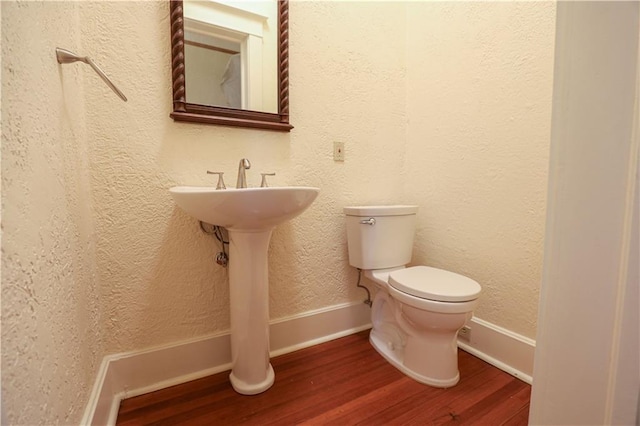 bathroom with wood-type flooring and toilet