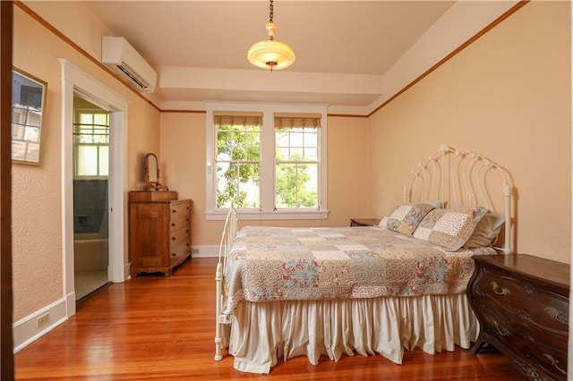 bedroom featuring hardwood / wood-style flooring and a wall mounted air conditioner