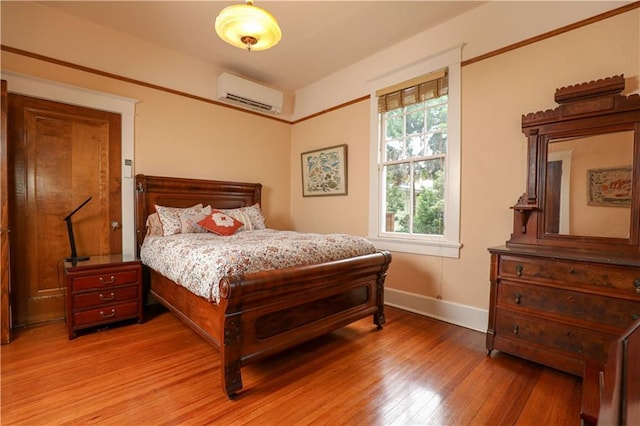 bedroom featuring a wall mounted AC and hardwood / wood-style flooring