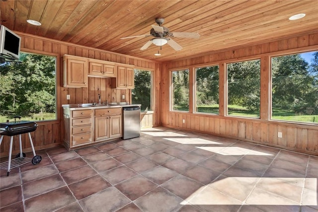 unfurnished sunroom featuring wood ceiling and ceiling fan