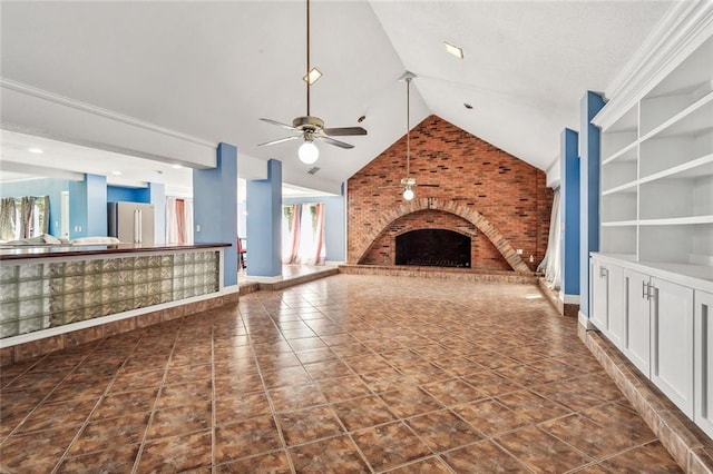 unfurnished living room with dark tile patterned flooring, ceiling fan, a brick fireplace, and plenty of natural light