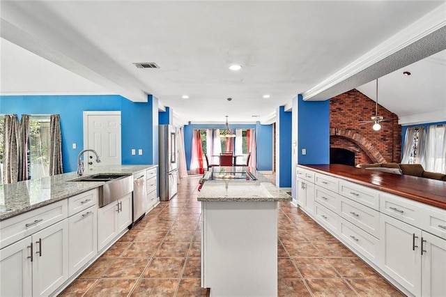 kitchen with a fireplace, hanging light fixtures, and plenty of natural light