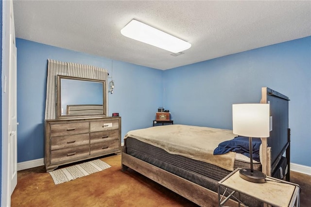 bedroom with a textured ceiling and dark colored carpet