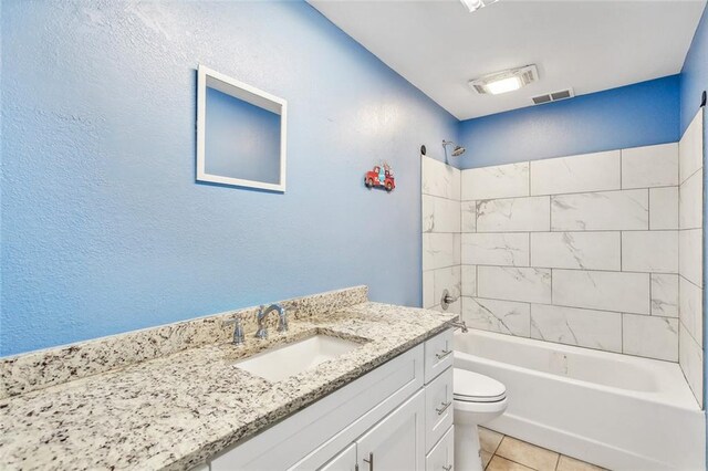 full bathroom featuring tiled shower / bath, vanity, toilet, and tile patterned floors