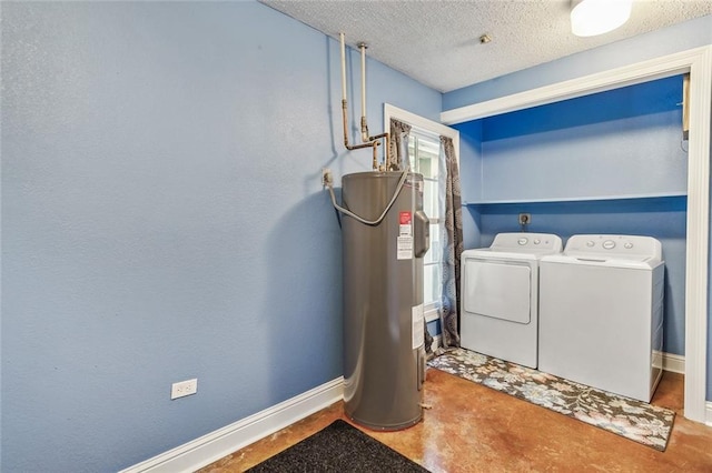 washroom with a textured ceiling, electric water heater, and washing machine and dryer