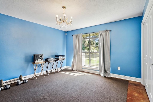 miscellaneous room with an inviting chandelier, a textured ceiling, and dark colored carpet