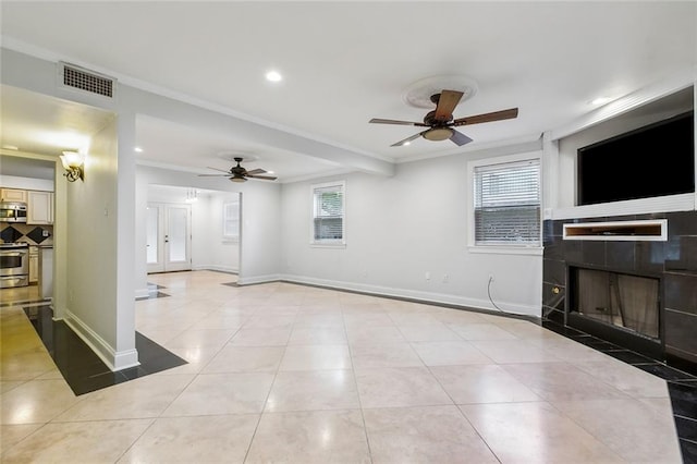 tiled living room featuring ornamental molding, a fireplace, and ceiling fan