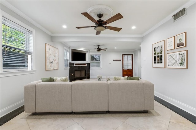 tiled living room featuring ornamental molding, a fireplace, and ceiling fan