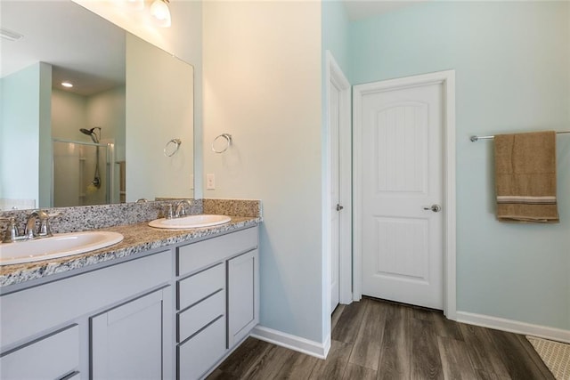 bathroom featuring a shower with door, hardwood / wood-style flooring, and vanity