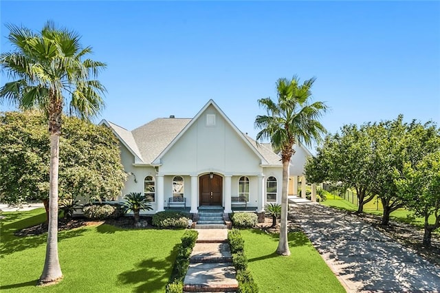 view of front of home with concrete driveway, a carport, roof with shingles, and a front lawn