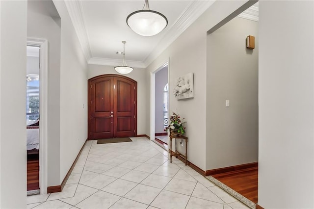 entrance foyer featuring light wood-type flooring, ornamental molding, and plenty of natural light