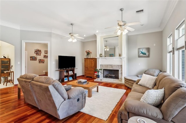 living room with ornamental molding, hardwood / wood-style flooring, and a tiled fireplace