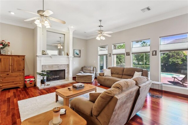 living room featuring visible vents, a ceiling fan, crown molding, and wood finished floors