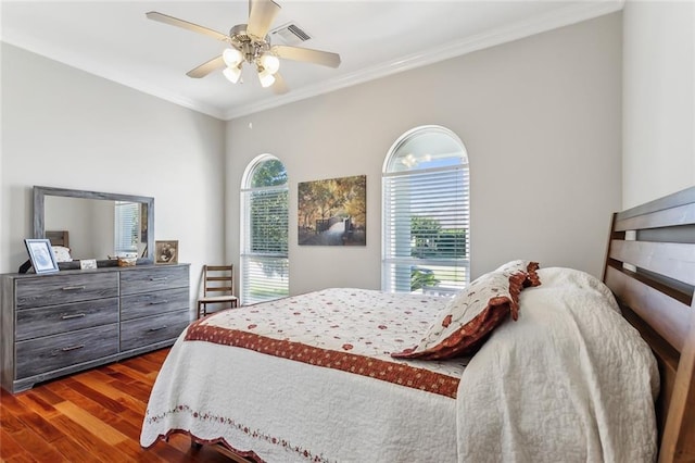 bedroom featuring multiple windows, dark hardwood / wood-style floors, crown molding, and ceiling fan