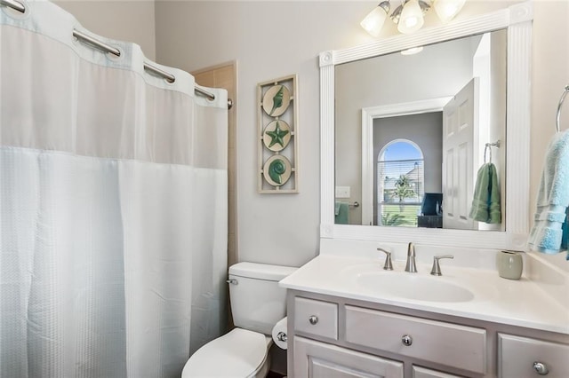 bathroom featuring vanity, toilet, and walk in shower