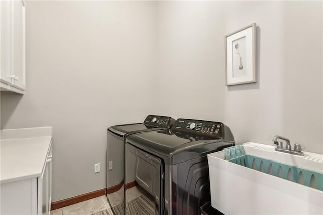 laundry area with sink, washer and dryer, cabinets, and light tile patterned floors