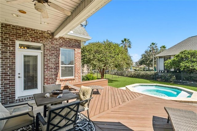 wooden terrace with a yard, a fenced backyard, an outdoor hot tub, and ceiling fan