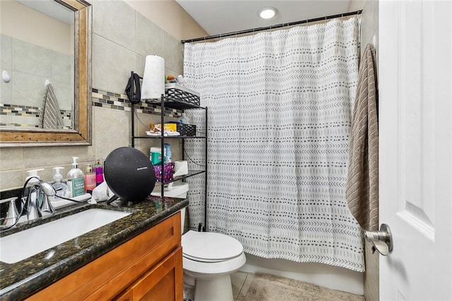 bathroom with curtained shower, vanity, tile walls, and toilet