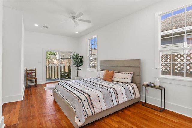 bedroom with access to outside, hardwood / wood-style floors, and ceiling fan