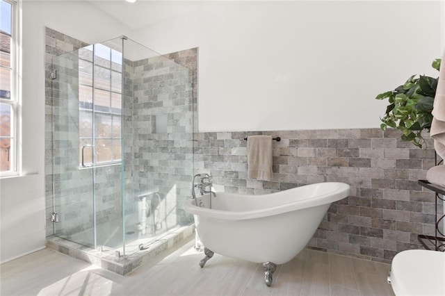 bathroom featuring toilet, tile walls, hardwood / wood-style floors, and plus walk in shower