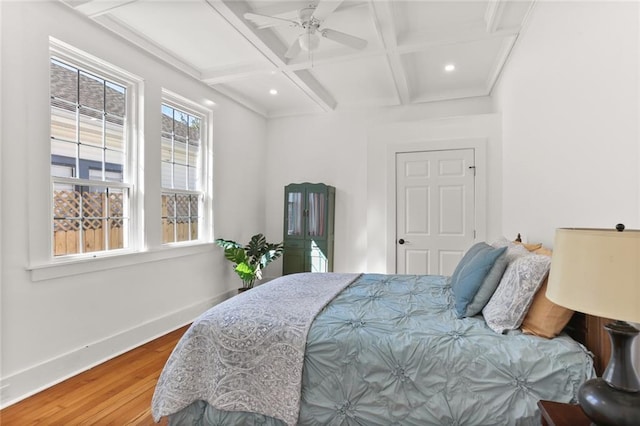 bedroom with beamed ceiling, coffered ceiling, wood-type flooring, and ceiling fan