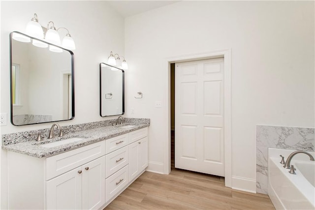 bathroom with a tub, vanity, and hardwood / wood-style flooring