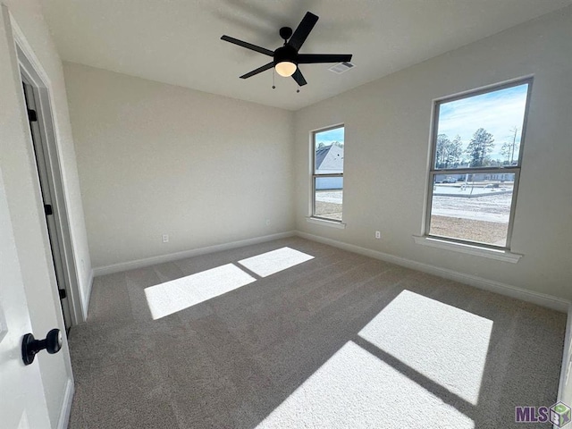 unfurnished bedroom featuring carpet flooring, baseboards, ceiling fan, and visible vents
