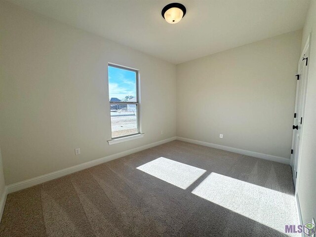 empty room featuring baseboards and carpet flooring
