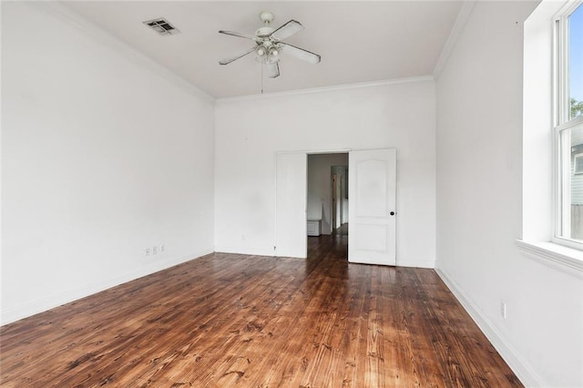 unfurnished room featuring a ceiling fan, baseboards, wood finished floors, visible vents, and ornamental molding