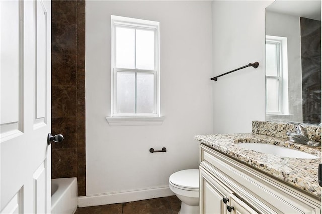 bathroom featuring baseboards, toilet, a healthy amount of sunlight, and vanity