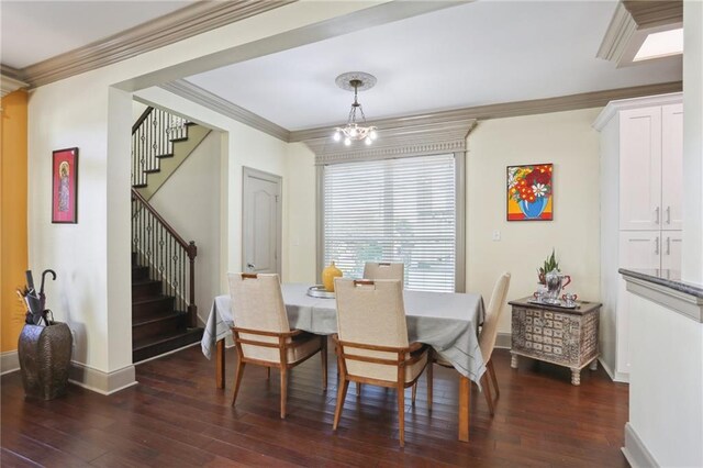 dining area with dark wood-type flooring, ornamental molding, and an inviting chandelier