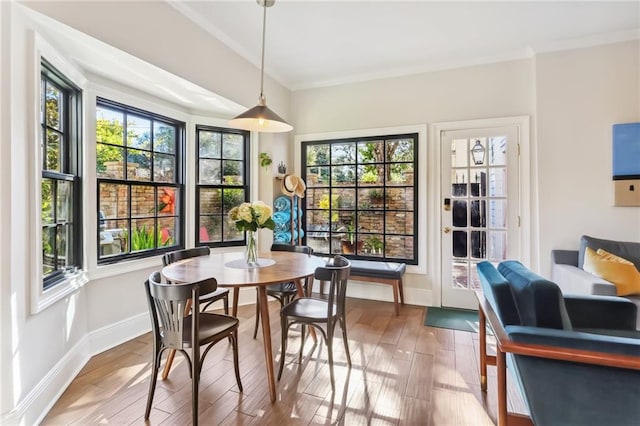 dining area with hardwood / wood-style flooring and crown molding